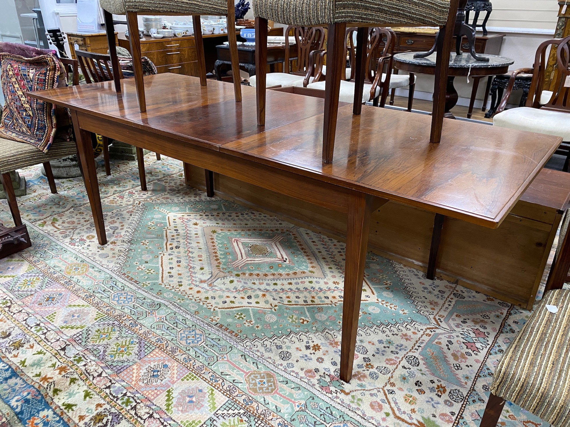 A mid century rosewood extending dining table, length 214cm extended, width 84cm, height 72cm six chairs and wall hanging side cabinet